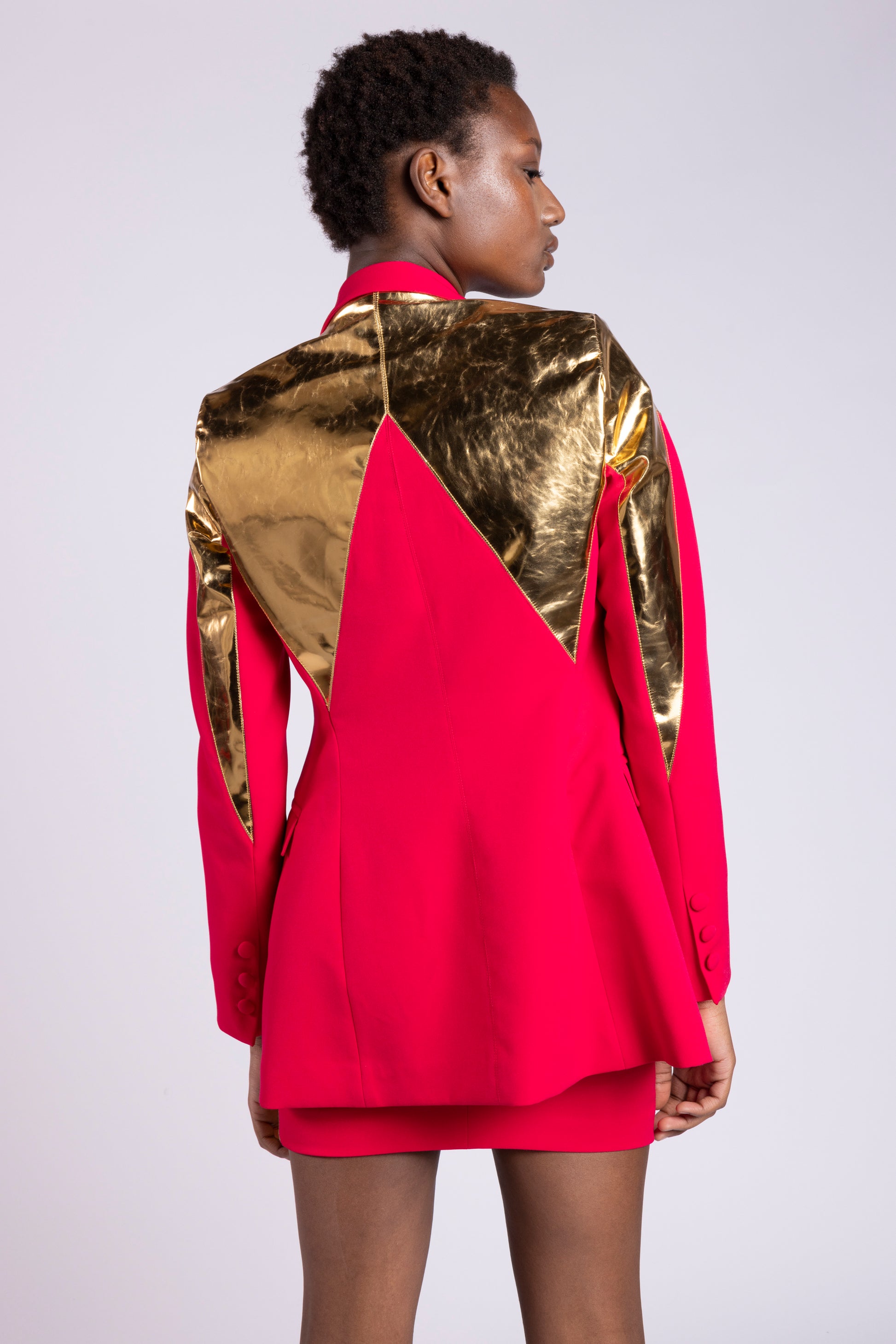 Tailleur da donna su misura con giacca doppio petto color fragola e inserti in pelle oro specchiato con pantaloncino in cady