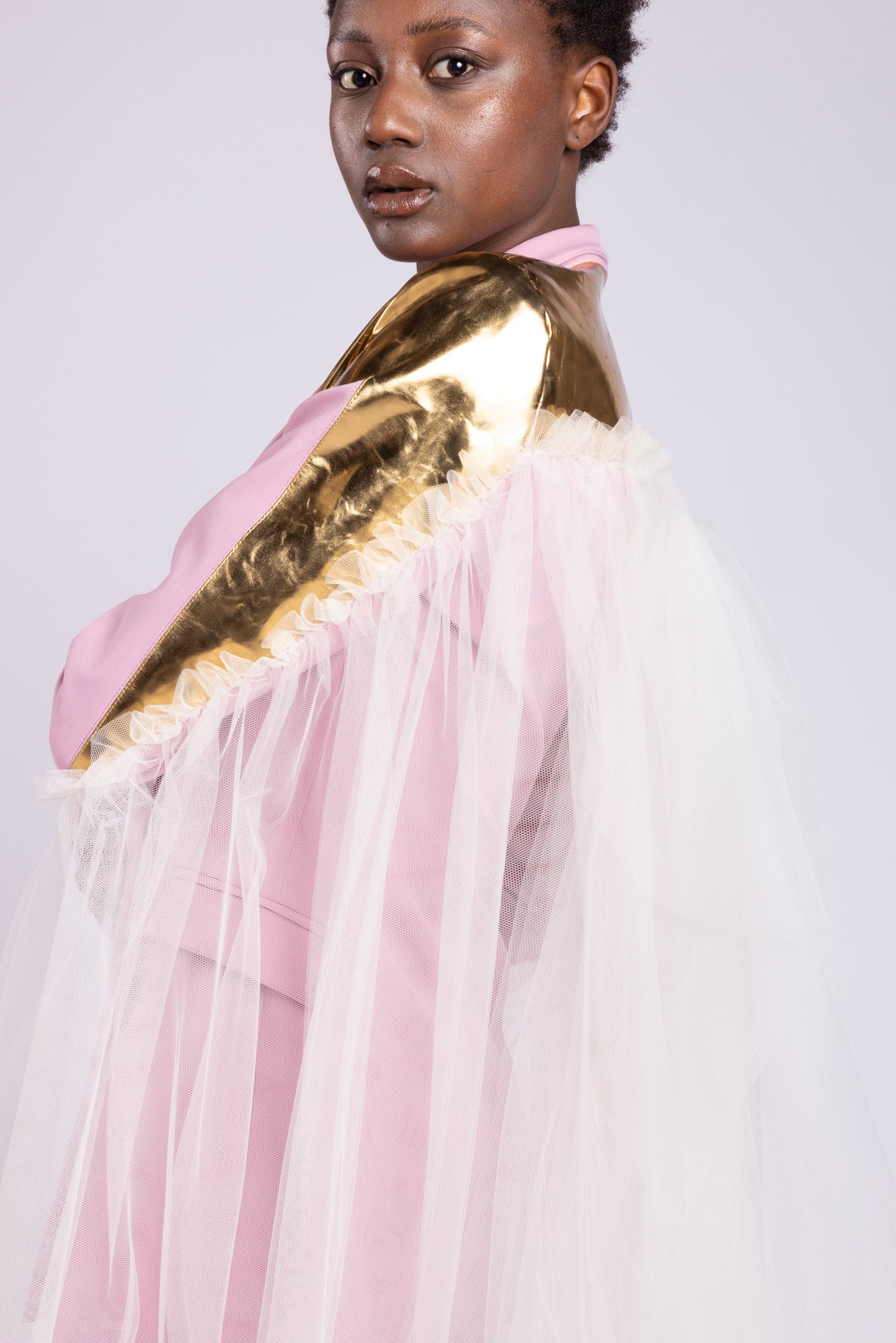 Tailleur da donna su misura con giacca doppio petto in cady rosa e dettagli in pelle oro specchiata con gonna in cady e pelle e mantello in tulle primavera estate